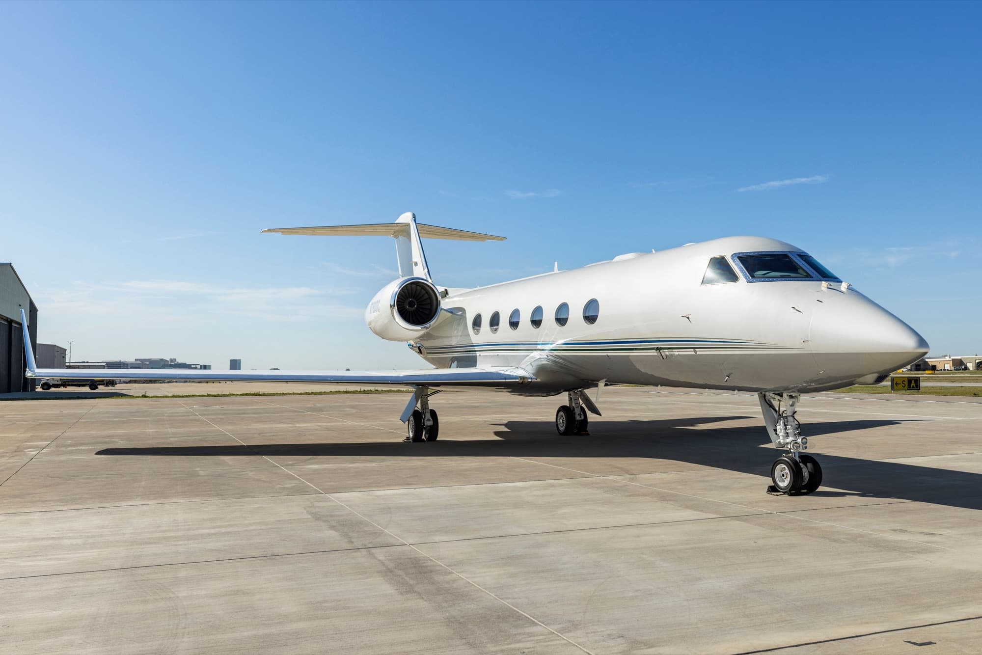 Gulfstream G450 three-quarter front view on the ramp by the hangar
